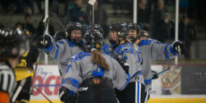 Minnesota Whitecaps players Jonna Albers (#3), Liz Schepers (#21), Sydney Brodt (#14), Sydney Baldwin (#9), and Olivia Knowles (#24), wearing their grey alternate jerseys, celebrate the game's opening goal by Brodt.