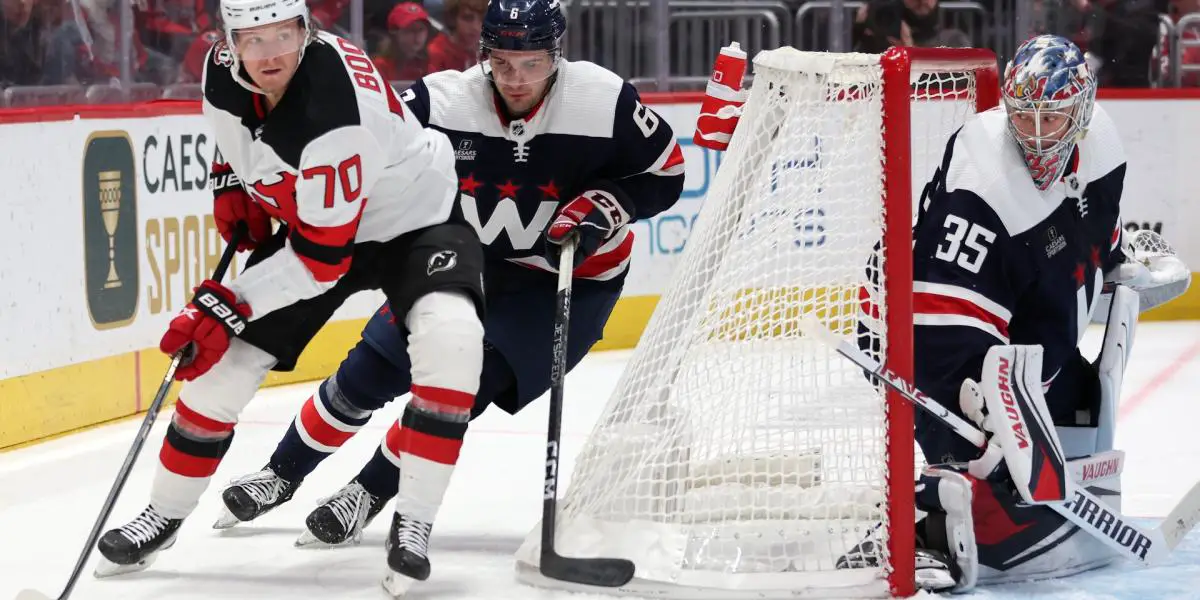 Washington Capitals goaltender Darcy Kuemper, right, looks at the play as Jesper Boqvist controls the puck for the New Jersey Devils behind the net against defender Vincent Iorio.