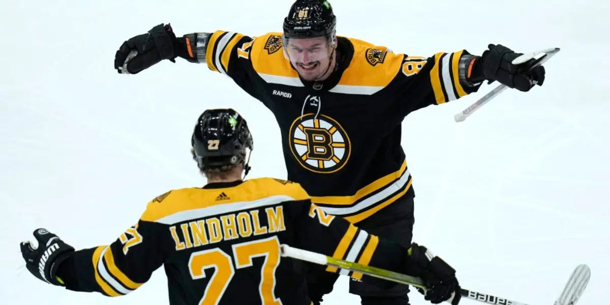 Boston Bruins defenseman Dmitry Orlov, top, is congratulated by Hampus Lindholm (27) after his goal against the Buffalo Sabres during the second period of an NHL hockey game, Thursday, March 2, 2023, in Boston. (AP Photo/Charles Krupa)