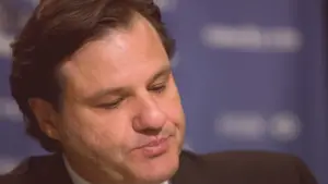 Francesco Aquilini, owner of the Vancouver Canucks, wearing a frustrated and concerned expression at a press conference.