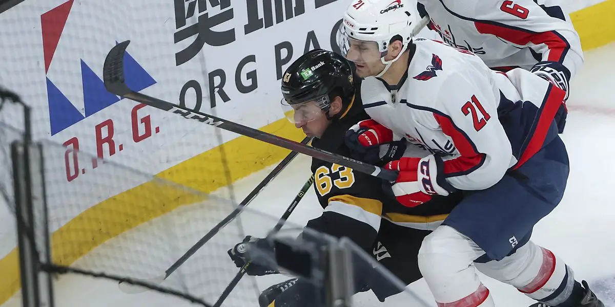 Garnet Hathaway, of the Washington Capitals at the time, checks Brad Marchand of the Boston Bruins.