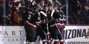 Coyotes celebrate after Clayton Keller scores a goal against the Boston Bruins