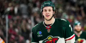 Brock Faber in a Minnesota Wild jersey smiling at the camera
