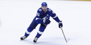 Steven Stamkos uses body and stick positioning to begin directing a player a way.