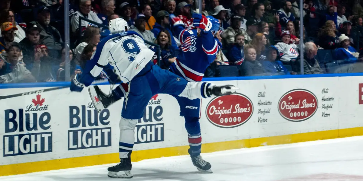 Gabriel Fornier takes a hit from a Rochester Americans player to make a play