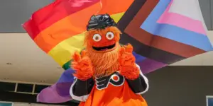 Gritty throwing peace signs in front of pride flag