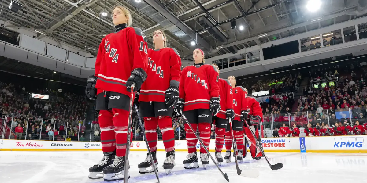 PWHL Players standing at the blue line for the anthems.