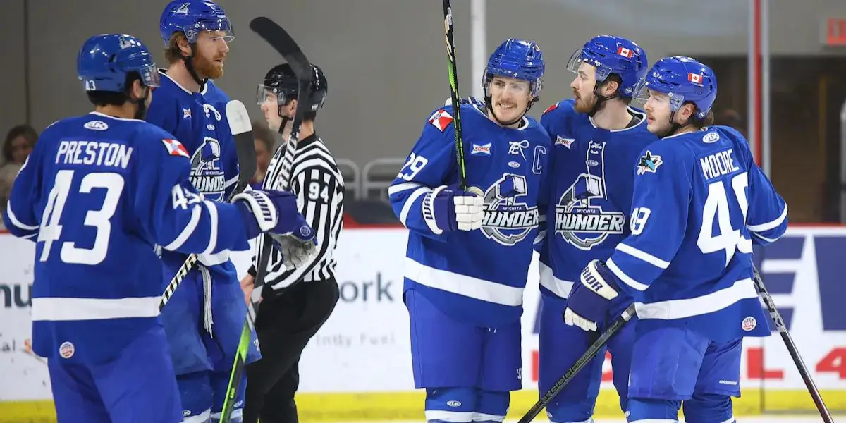 Several Wichita Thunder players gather on the ice.