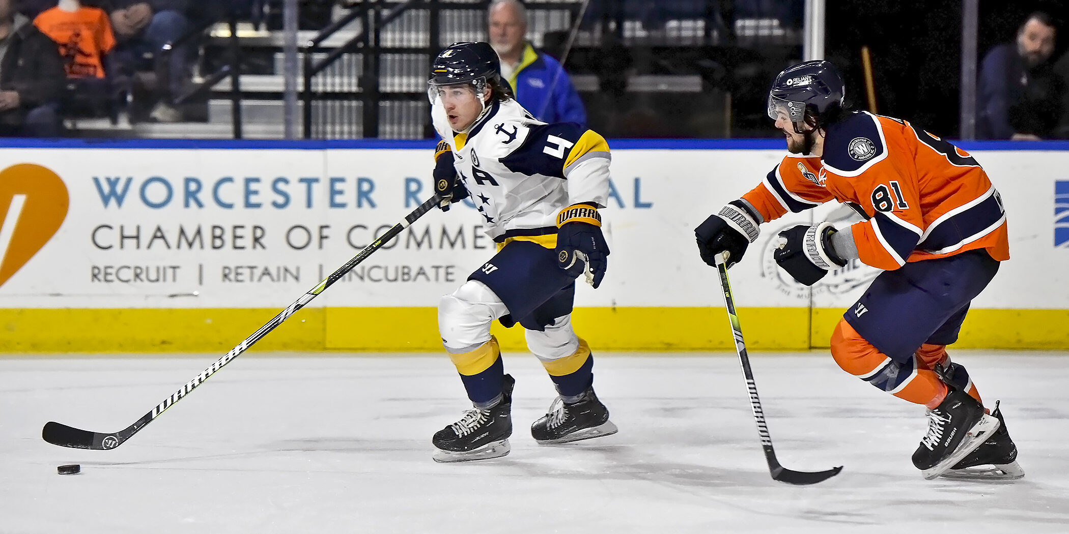 Carson Musser skates up ice with the puck and a Worcester Railers' player on him