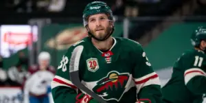 Ryan Hartman wearing a green Minnesota Wild jersey on the ice