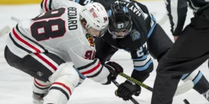 Connor Bedard taking a faceoff against the Utah Hockey Club