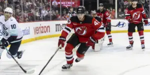 Luke Hughes races for a loose puck against the Seattle Kraken.