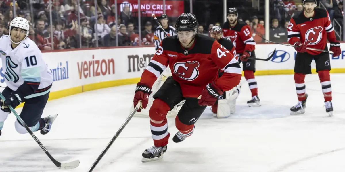 Luke Hughes races for a loose puck against the Seattle Kraken.