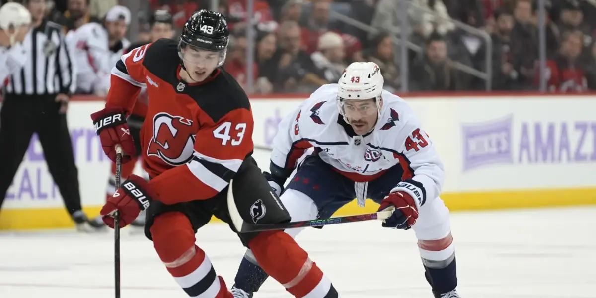 Luke Hughes makes a play in front of Tom Wilson.