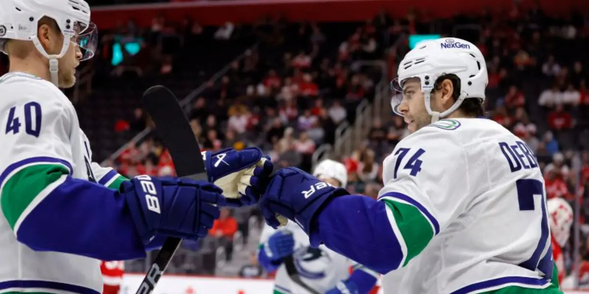 Jake DeBrusk and Elias Pettersson celebrating a goal for the Vancouver Canucks