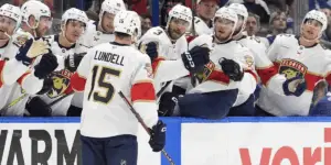 Lundell celebrates his goal with his teammates on the bench.